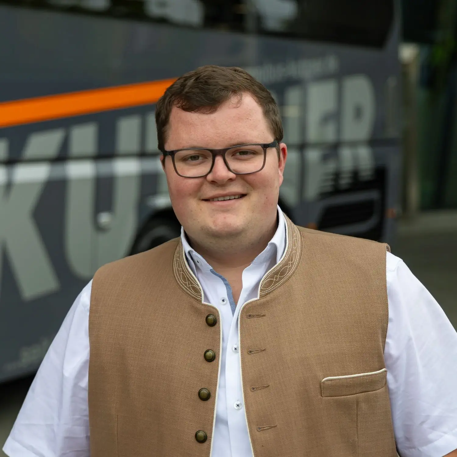 Busunternehmer Maximilian Kutzner Ein Portrait von Busunternehmer und Chef Maximilian Kutzner. Im Hintergrund ist unscharf ein Kutzner-Bus erkennbar.