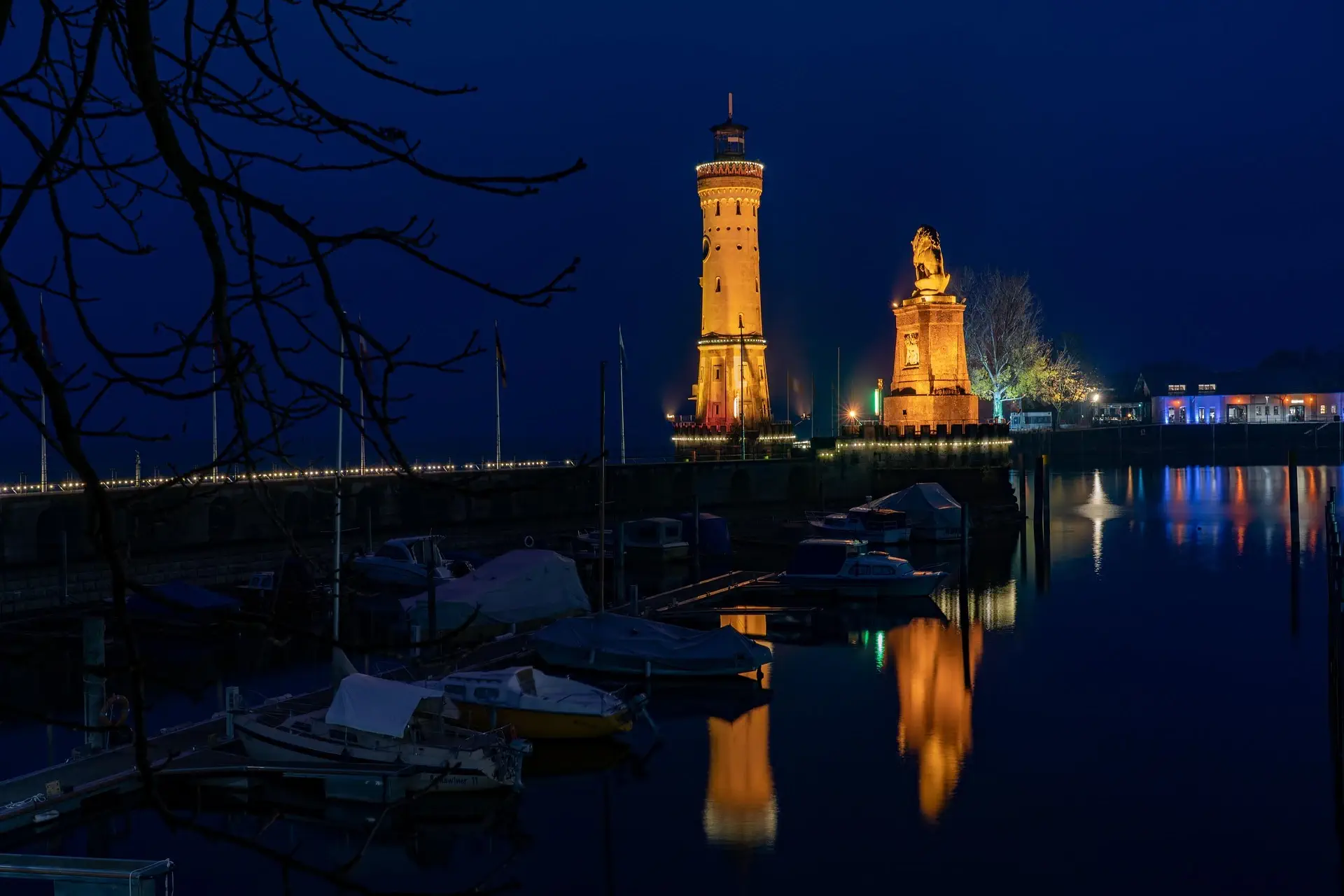 Der Leuchtturm am Bodensee beschienen bei Nacht.